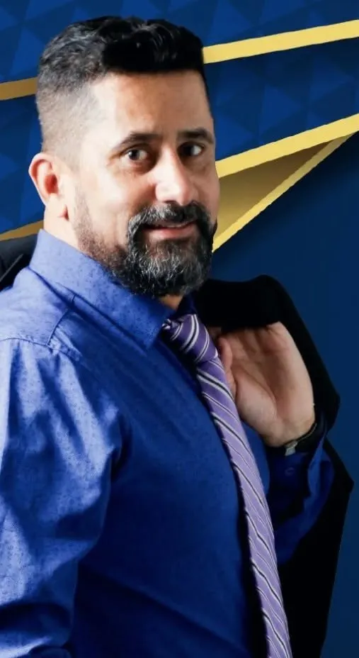 Fernando Rodrigues de Paula de camisa social e gravata, com o paletó no ombro